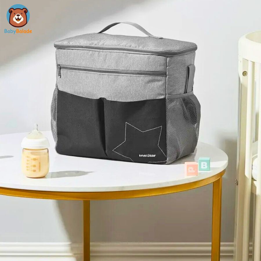 sac à langer poussette de couleur gris posé sur la table