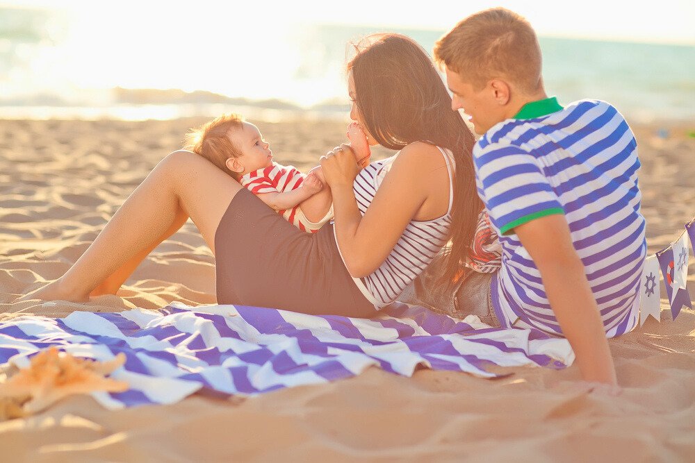 Sortir avec bébé en été - bébé et ses parents à la plage