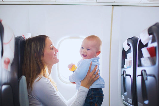 Voyage en Avion avec Bébé dans les bras de maman souriante