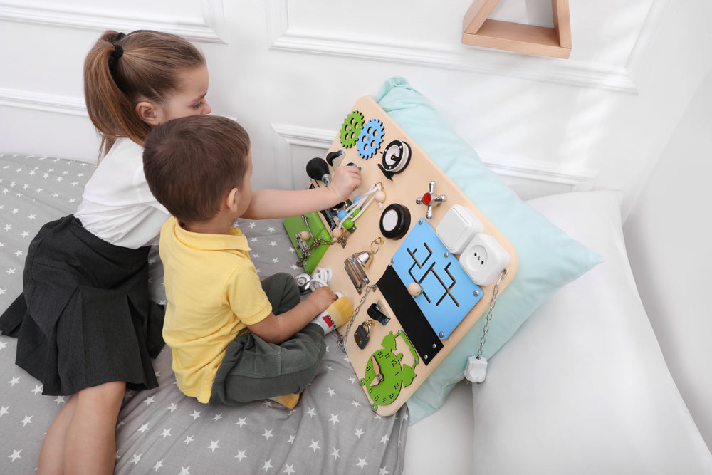 deux enfants jouant au busy board Montessori