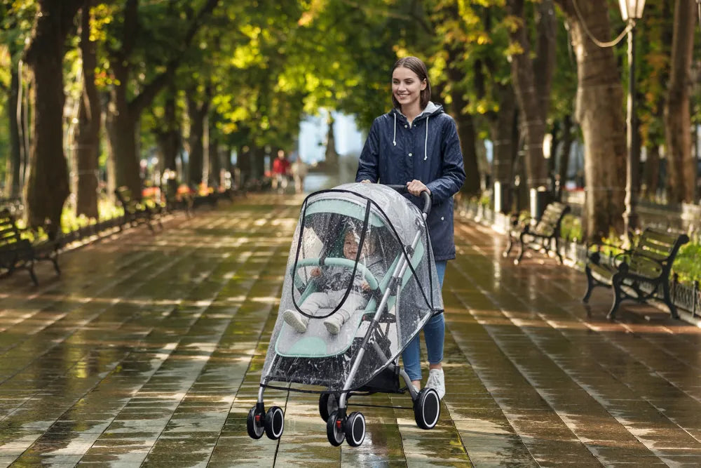 habillage pluie poussette qui couvre bébé sous la pluie avec maman
