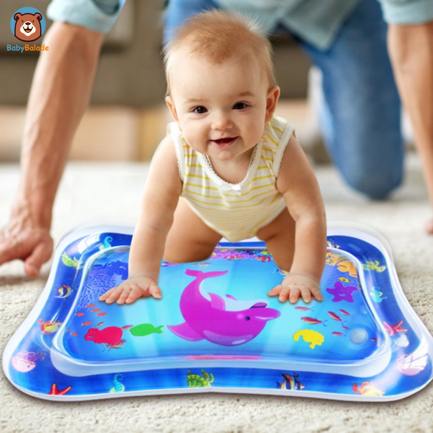 Tapis d'eau bébé - bébé assis avec le sourire sur le tapis